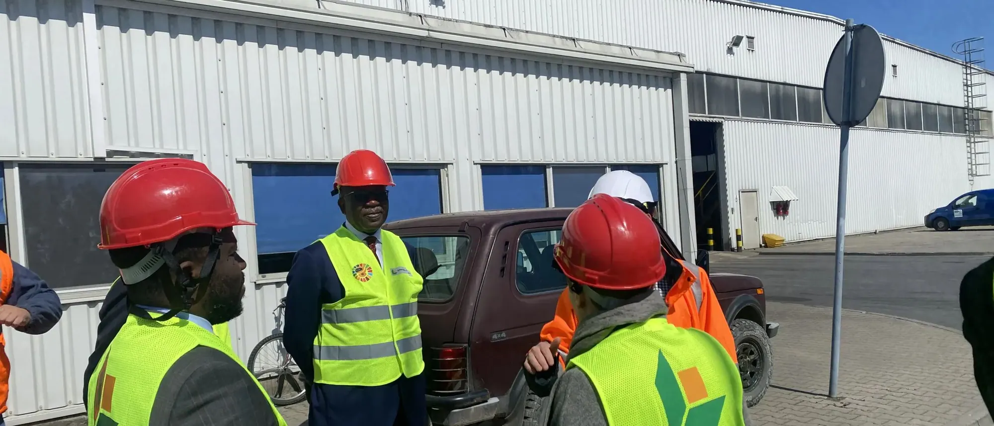 Team in hard hats and high-visibility vests during a site visit at an industrial facility